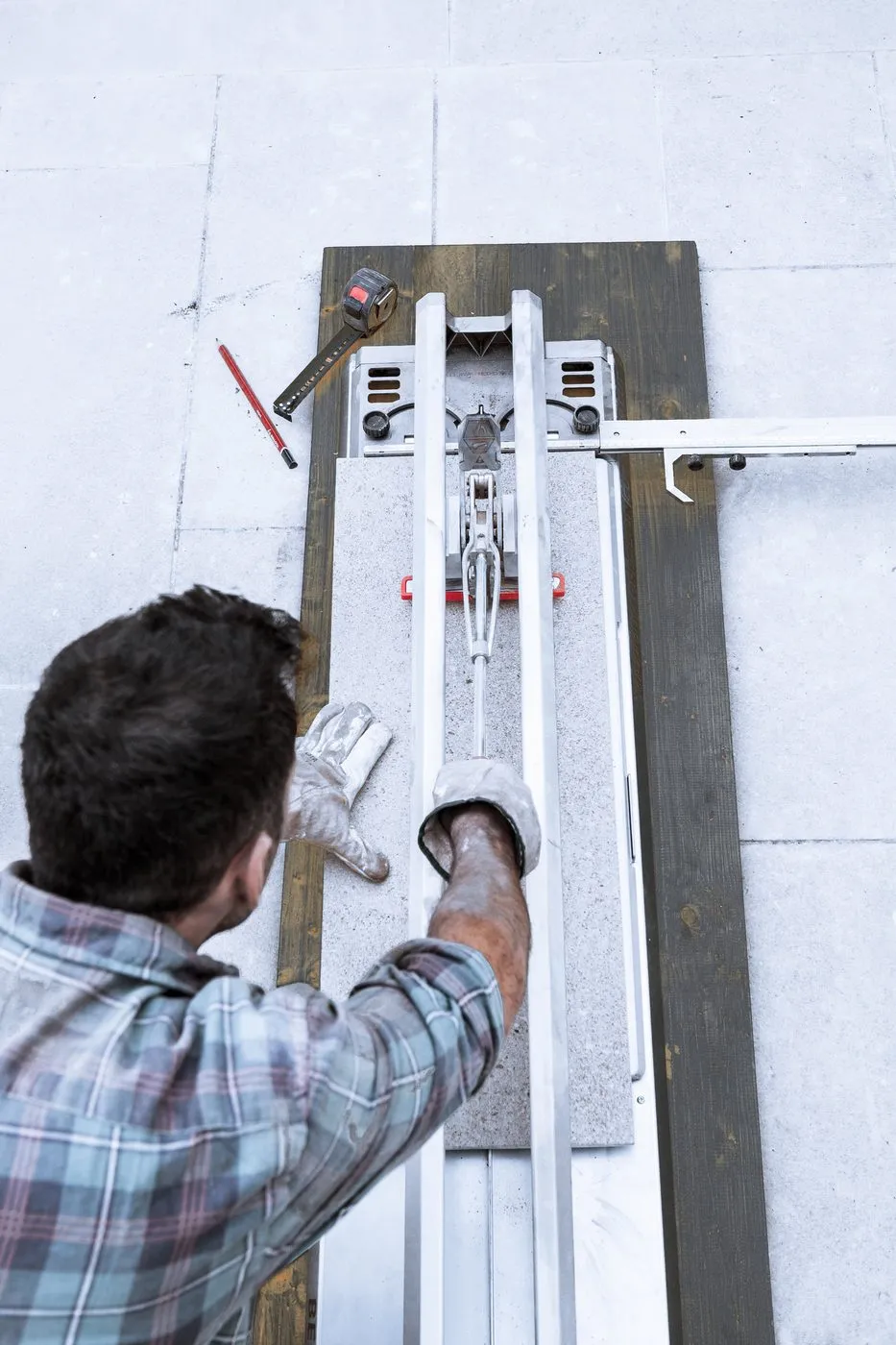 Tiler cutting a tile with a professional tile cutter