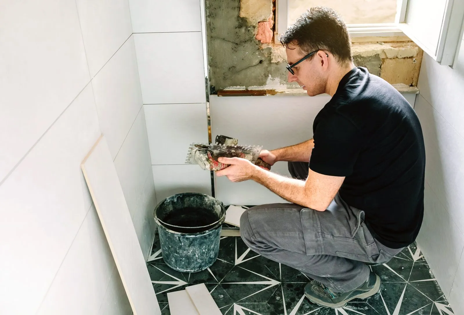 ASA Tiling tradesman laying wall tiles during a bathroom renovation